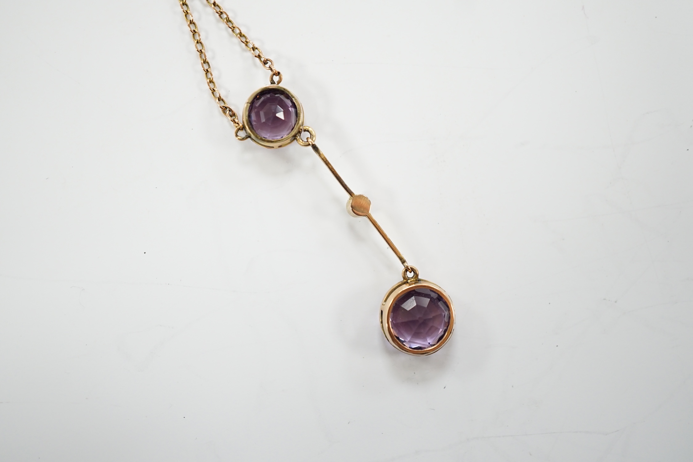 An Edwardian 9ct, two stone amethyst and single stone seed pearl set drop pendant necklace, gross weight 3.8 grams.